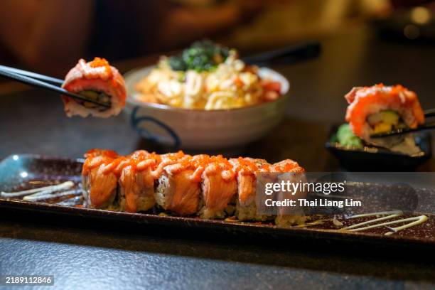 sushi roll with salmon, fish roe, and wasabi - ikura maki stock-fotos und bilder