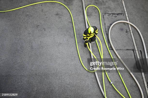 overhead view firefighter preparing water hose - feuerwache stock-fotos und bilder