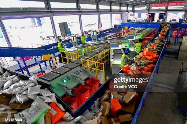 Employees sort express parcels at automated sorting lines in a distribution center of J&T Express ahead of China's Double 12 Shopping Festival on...