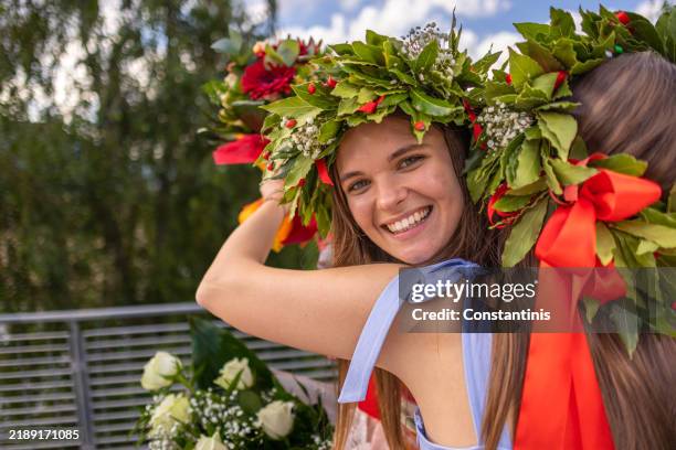 abbracciare gli amici con bouquet e corone d'alloro - laurea foto e immagini stock