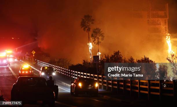 Firefighters work as the Franklin Fire burns near a building on December 10, 2024 in Malibu, California. The wildfire has scorched 1,800 acres near...