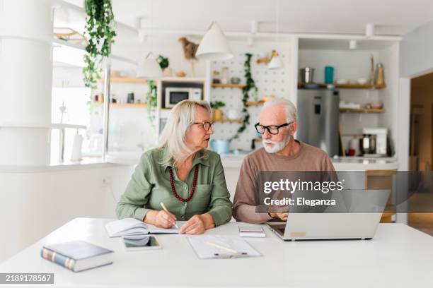 senior couple using laptop while planning their home budget, - pension stock pictures, royalty-free photos & images