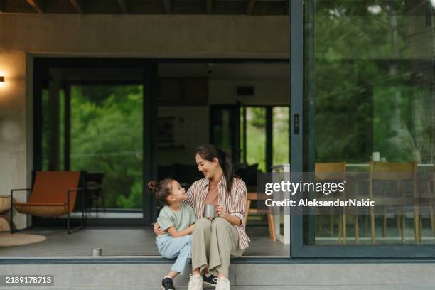 madre e hija compartiendo un momento alegre en el porche - familia de dos generaciones fotografías e imágenes de stock