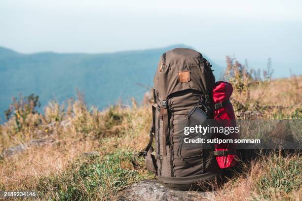 backpack on a scenic mountain trail with gear for hiking and camping - camping backpack stock pictures, royalty-free photos & images