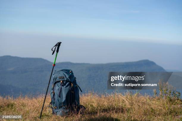 backpack and trekking pole on a mountain ridge with scenic view - travel essentials stock pictures, royalty-free photos & images