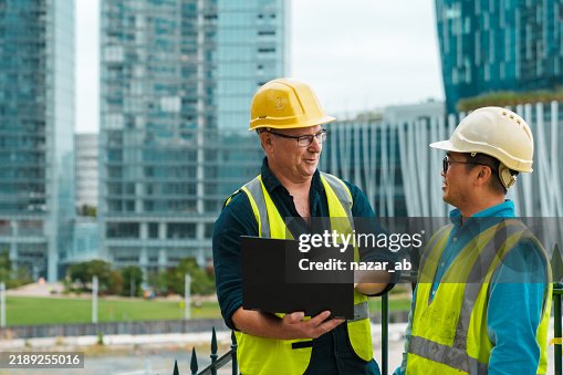 Construction engineers using laptop during site inspection. Construction engineers using laptop during site inspection.