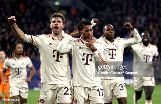 Michael Olise of Bayern Munich celebrates scoring his team's third goal from the penalty spot with teammate Thomas Mueller during the UEFA Champions...