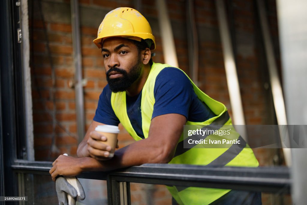 Construction Worker Taking A Coffee Break at Building Site