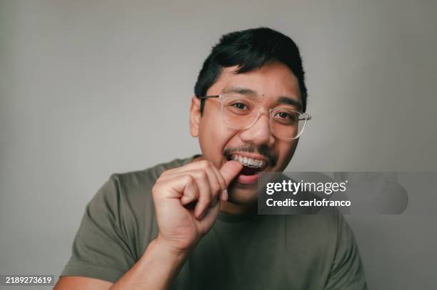 clear braces - dental aligner - filipino man - studio shot - aparelho dentário imagens e fotografias de stock