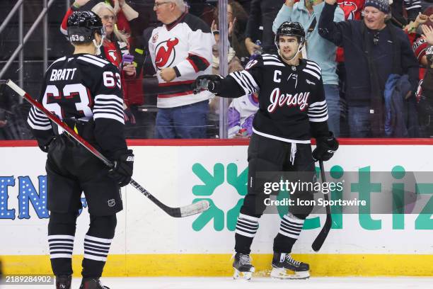 New Jersey Devils center Nico Hischier celebrates with New Jersey Devils left wing Jesper Bratt after scoring a goal during a NHL game between the...