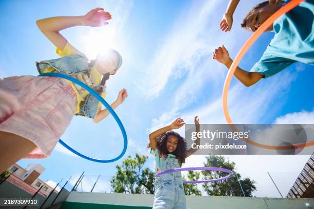 escolares multiétnicos felices jugando con aros de hula al aire libre - patio de colegio fotografías e imágenes de stock
