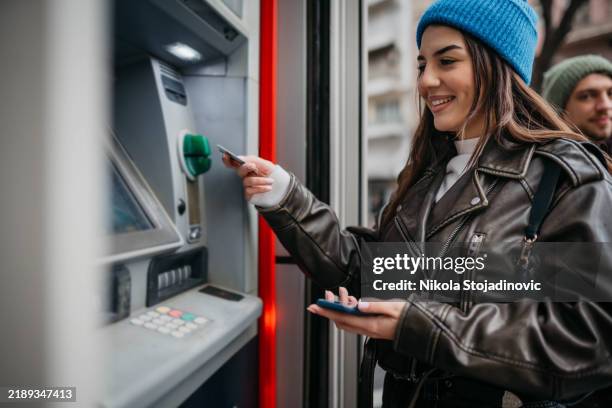 picking up the cash - atm stock pictures, royalty-free photos & images