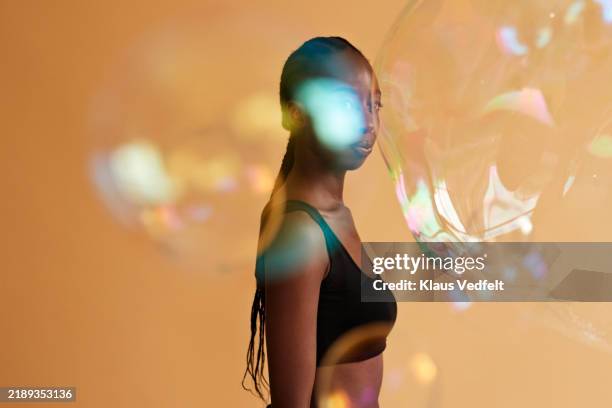 woman seen through large translucent bubbles - crop top stock pictures, royalty-free photos & images