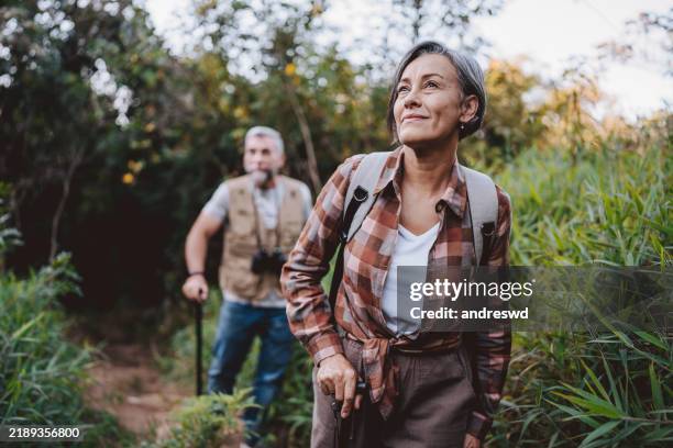 senior couple walking on forest mountain trail - nature stock pictures, royalty-free photos & images