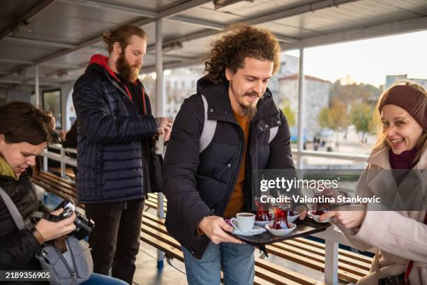 smiling man proudly serving his friends with some tea - turkish food stock pictures, royalty-free photos & images