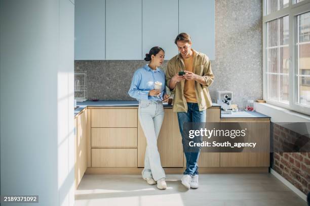 couple enjoying coffee during relaxed kitchen chat - ungt par bildbanksfoton och bilder