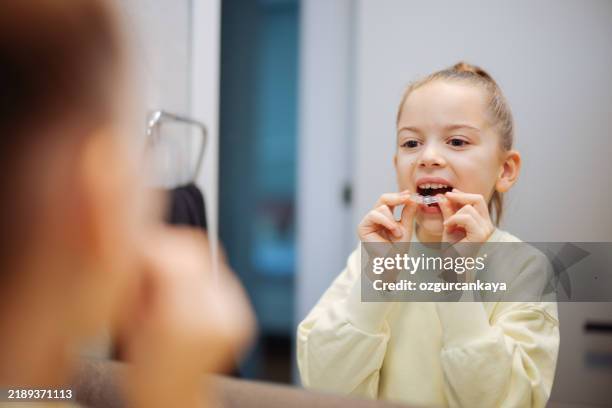 little girl holding invisible dental aligners - aparelho dentário imagens e fotografias de stock