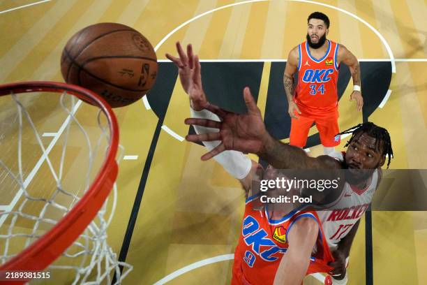 Oklahoma City Thunder guard Alex Caruso and Houston Rockets forward Tari Eason reach for the ball in the first half of a semifinal game of the...