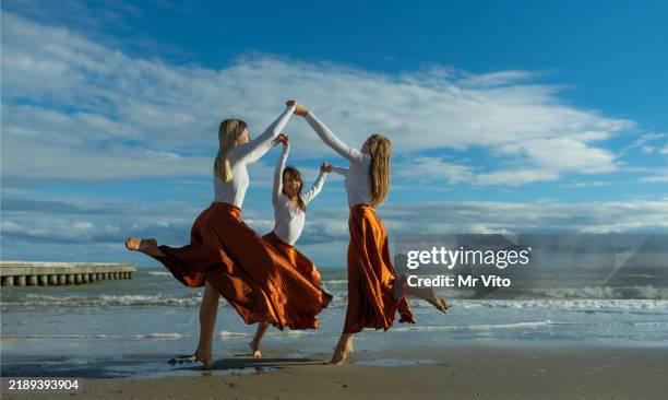 three teenage dancers dance a dance on the beach. - contemporary dance stock pictures, royalty-free photos & images