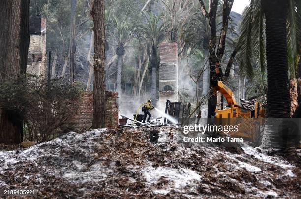 Los Angeles County Fire Department firefighter works to put out hotspots at a home destroyed in the Franklin Fire on December 11, 2024 in Malibu,...