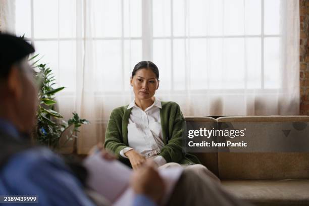 counseling session with therapist and patient in a well-lit office - warm light stock pictures, royalty-free photos & images