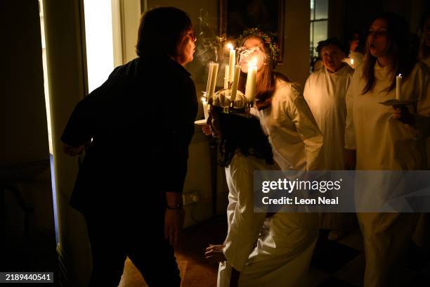Candles are extinguished from a crown after members of the London Nordic Choir perform for guests during a St Lucia celebration at the Swedish...