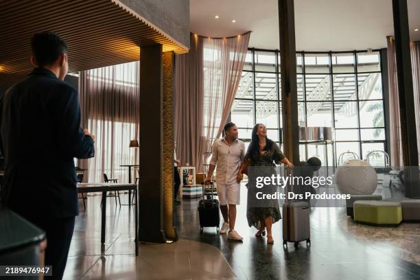 couple checking in at hotel - hotel de lujo fotografías e imágenes de stock