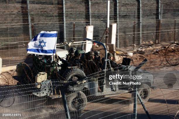 Israeli troops and military vehicles cross in and out of Syria through a gate in the boundary fence near the Druze village of Majdal Shams on the...