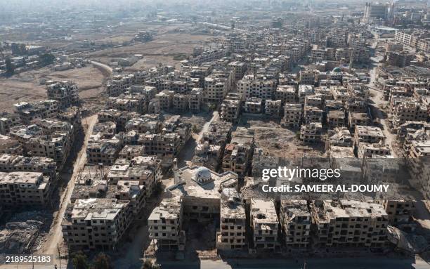 This aerial picture shows destroyed buildings in the city of Harasta in Eastern Ghouta on the outskirts of Damascus on December 15, 2024....