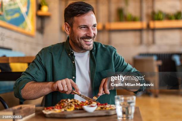 tasting italy - mann genießt authentische pizza in einer lokalen pizzeria - cholesterin stock-fotos und bilder