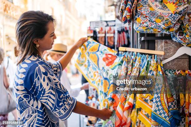 Young Brazilian Woman Shopping For Scarfs At The Street Market In Taormina In Sicily