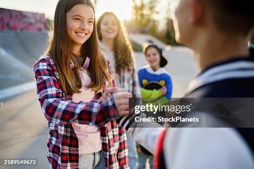 Girl and boy shake hands in the skate park Girl and boy shake hands in the skate park