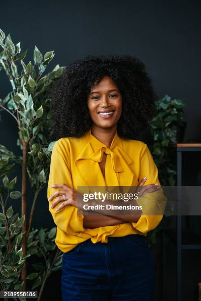 confident businesswoman smiling with folded arms in modern office - resourceful stock pictures, royalty-free photos & images