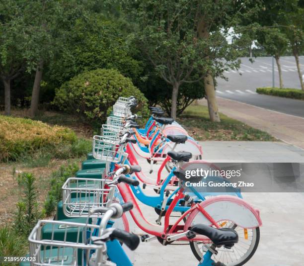 shared bicycles on urban streets - bicycle parking sign stock pictures, royalty-free photos & images