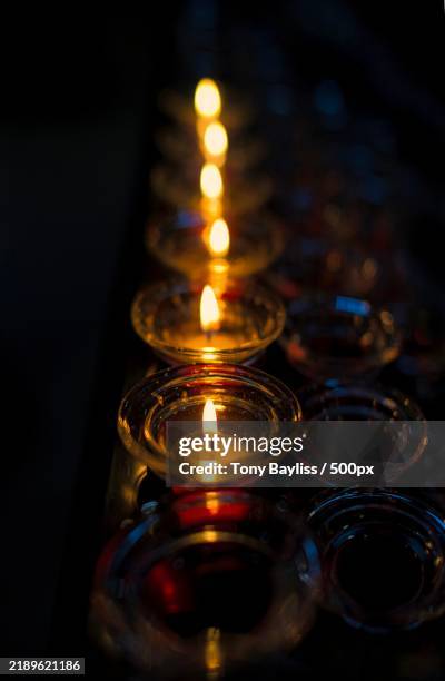 close-up of illuminated candles on table - candela tealight foto e immagini stock