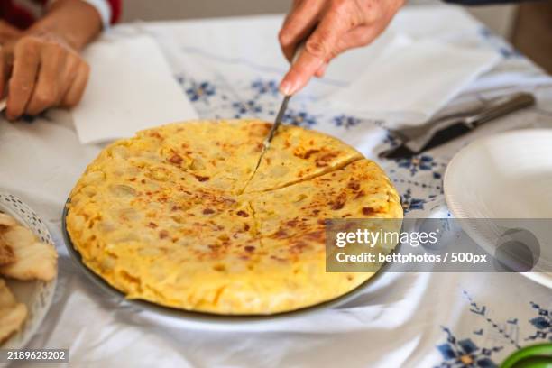 cropped hand of person preparing food in kitchen - tortilla de patata fotografías e imágenes de stock
