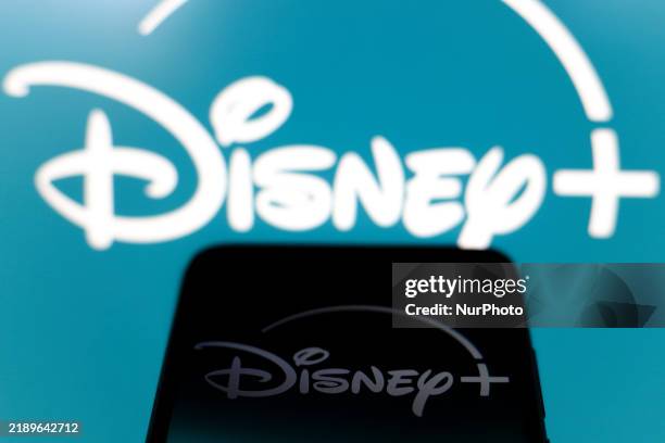 The Disney Plus logo appears on the screen of a smartphone and in the background on the computer screen in Reno, United States, on December 15, 2024.