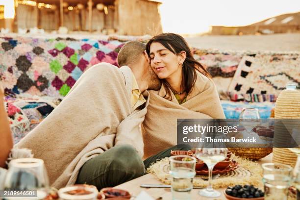 medium shot couple in romantic moment while wine outside at desert camp - beige stock pictures, royalty-free photos & images