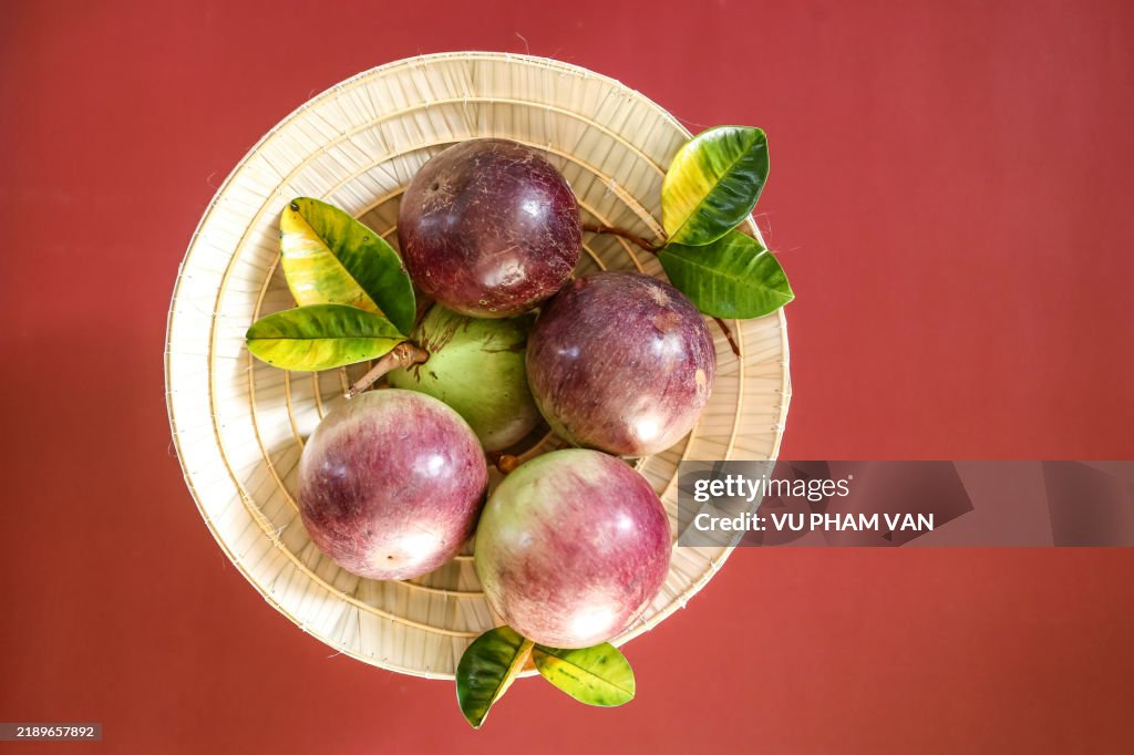 Star apple tropical fruits inside cone shaped straw hat