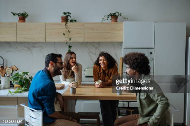 cheerful friends laughing and talking together in the kitchen - millennial generation stock pictures, royalty-free photos & images