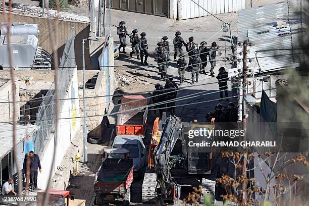 Israeli forces deploy an excavator to demolish a house belonging to the Palestinian Abu Diab family in the al-Bustan neighbourhood of the Arab town...