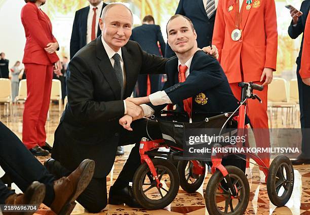 In this pool photograph distributed by the Russian state agency Sputnik, Russia's President Vladimir Putin poses for pictures with Russian...