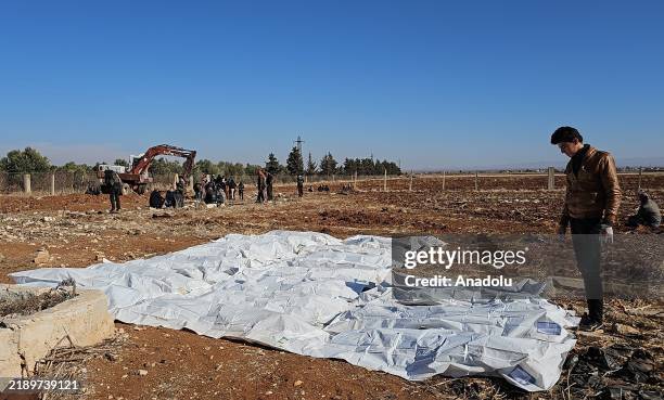 Teams work on the uncovered 12 mass graves, believed to contain the remains of civilians killed by the ousted Assad regime, in Daraa, Syria on...