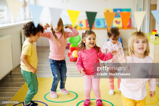 children play with hoops in the playroom - preschool age stock pictures, royalty-free photos & images