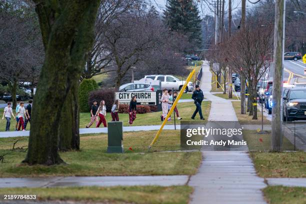 Students from Abundant Life Christian School are escorted to a city bus where they will reunited with their parents after a school shooting on...