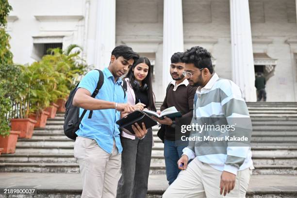 university students studying and discussing standing on the steps of the campus - povo indiano imagens e fotografias de stock