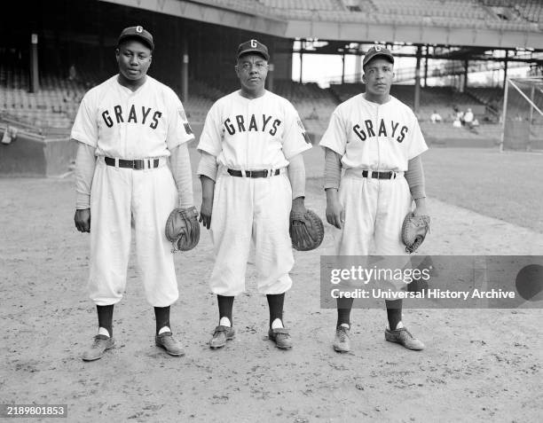 Washington Homestead Grays baseball players, Josh Gibson, Ted "Double Duty" Radcliffe, and Euthumn "Eudie" Napier, standing on the field at Griffith...