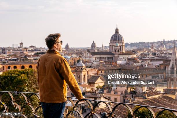 man looking at historic rome skyline at sunset from above, italy - esploratore foto e immagini stock