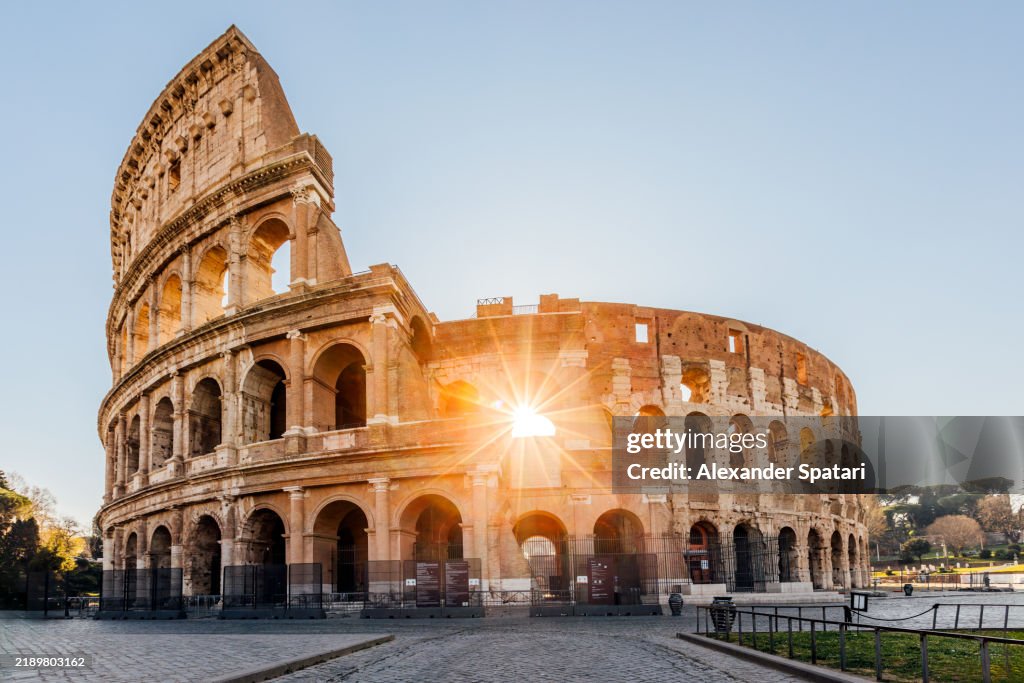 Rays of sun shining through the arches of Coliseum in the morning, Rome, Italy
