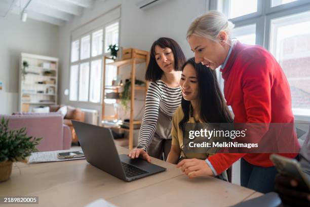 a group of colleagues engaged in a collaborative discussion - red shirt stock pictures, royalty-free photos & images